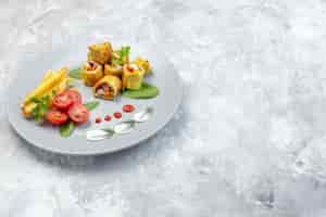 Free photo front view vegetable pate rolls with tomatoes and french fries inside plate on a white surface