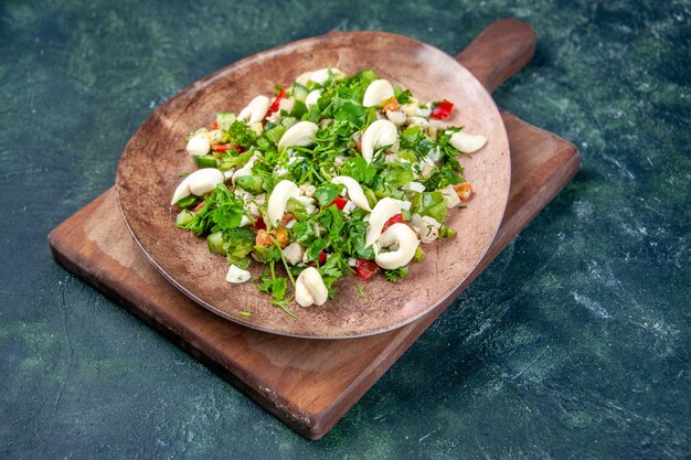 front view vegetable salad inside elegant plate on dark blue background