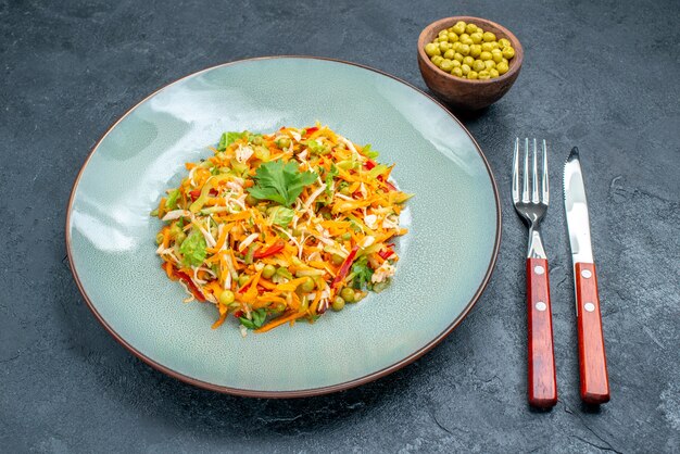 暗いテーブルの上の豆とプレートの内側の正面図野菜サラダ健康サラダダイエット食品