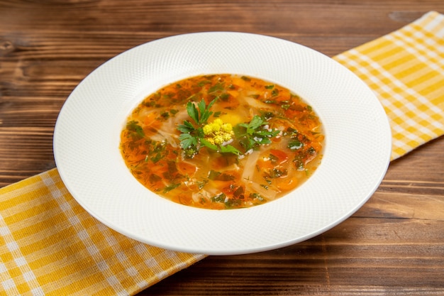 Front view vegetable soup with greens on brown wooden table soup food vegetable seasonings