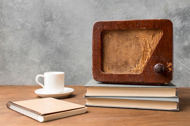 Вид спереди старинное радио на стопке книг и кофе
