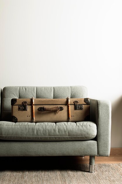 Вид спереди старинный чемодан на диване