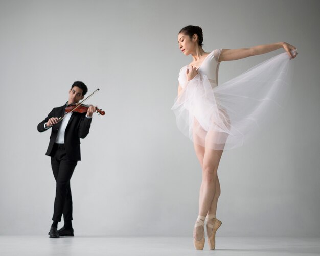 Вид спереди на скрипке музыканта с балериной
