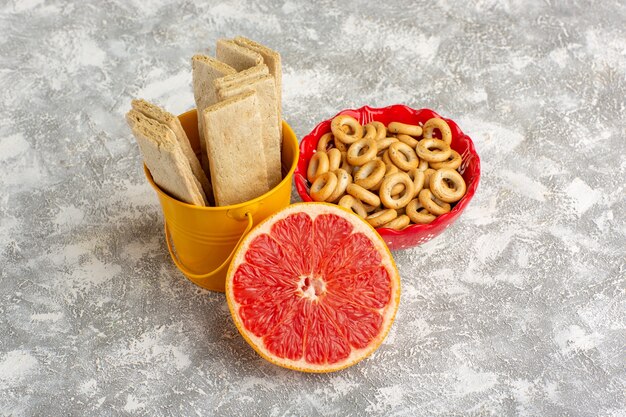 Front view waffles and crackers with grapefruit on white surface