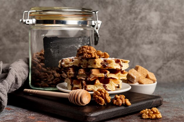 Front view of waffles stacked on plate with walnuts and sugar cubes