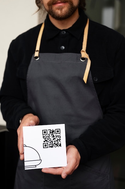 Free photo front view waiter holding qr code