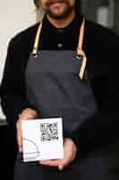 Free photo front view waiter holding qr code