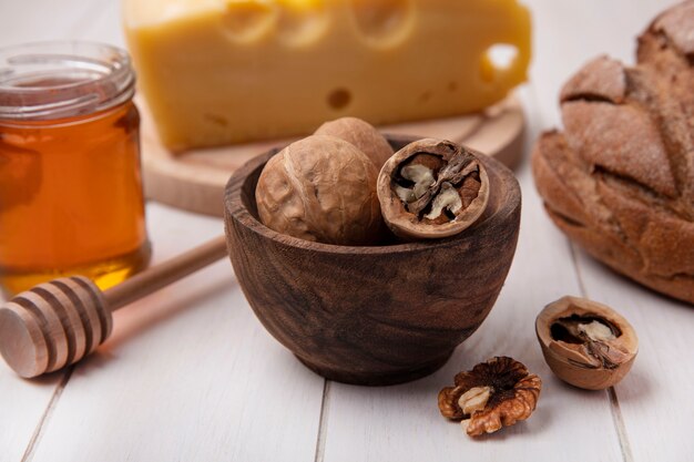 Front view walnuts with cheese  honey and black bread on a white background