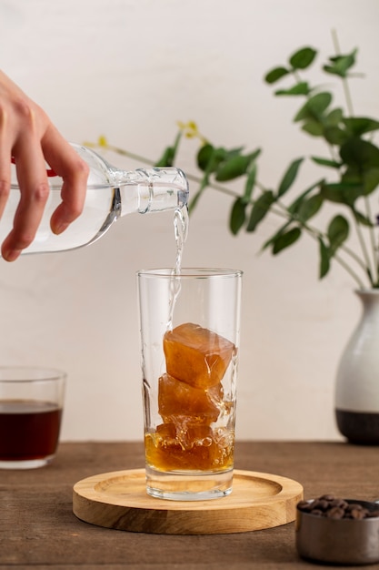 Front view water pouring over iced coffee