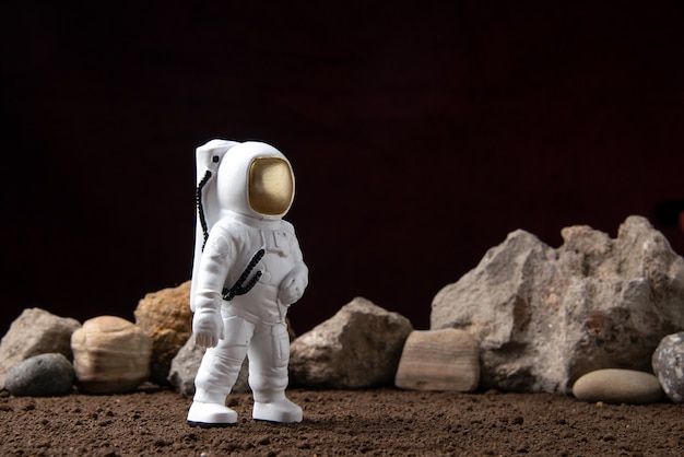 Free photo front view of white astronaut with rocks on moon cosmic sci fi