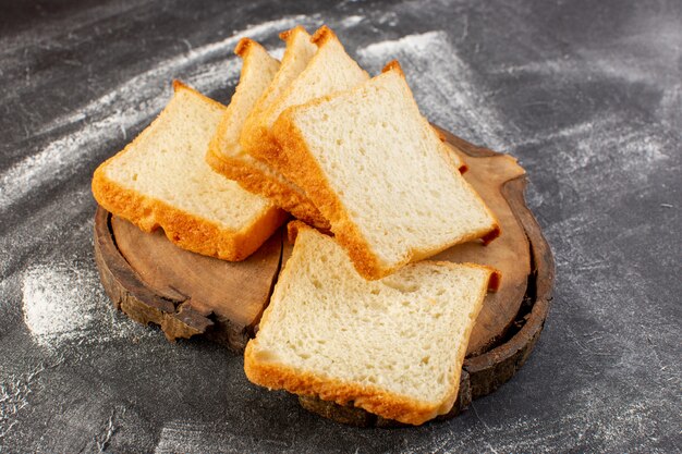 Front view white bread loafs sliced on wooden desk