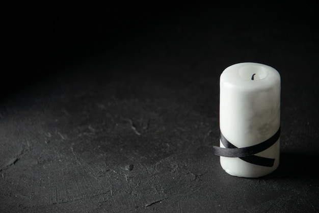 Front view of white candle on black