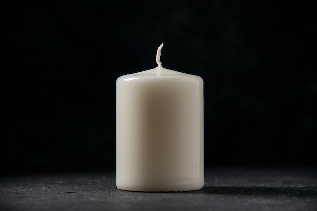 Front view of white candle on black