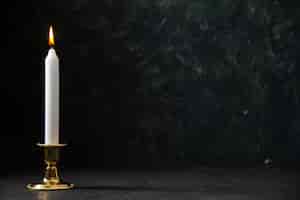 Free photo front view of white candle in golden stand on black