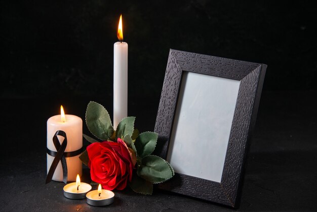 Вид спереди белая свеча с картинной рамкой и цветком на темной поверхности