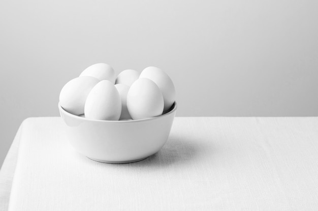 Free photo front view white chicken eggs in bowl with copy-space