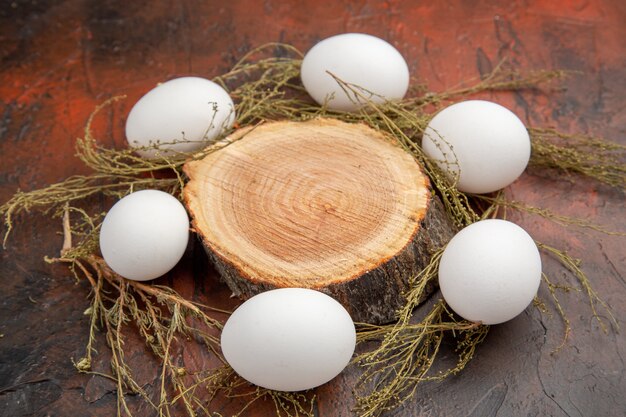 Front view white chicken eggs on dark surface