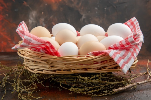 Free photo front view white chicken eggs inside basket with towel on dark surface