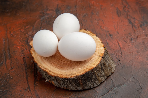 어두운 표면에 나무에 전면보기 흰색 닭고기 달걀