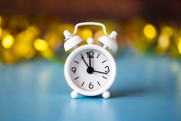 Front view white clock on blurred golden background