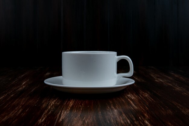 Front view white cup on a saucer on a wooden background