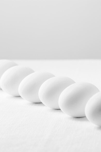 Вид спереди белые свежие яйца на столе