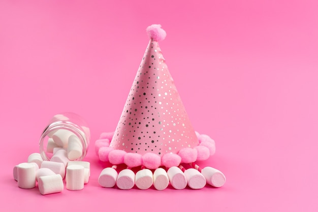 A front view white marshmallows inside can around pink birthday cap on pink