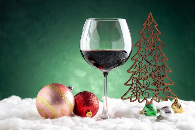 녹색 배경에 전면 보기 와인 잔 및 크리스마스 장식품