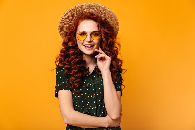 Front view of winsome ginger woman. Attractive caucasian girl smiling on yellow background.