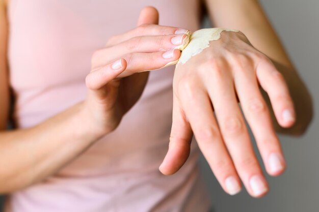 Front view of woman applying lotion on her hands