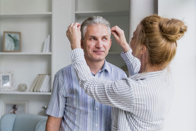 Front view woman arranging husbands hair