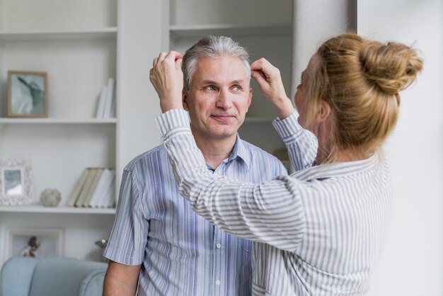 Front view woman arranging husbands hair