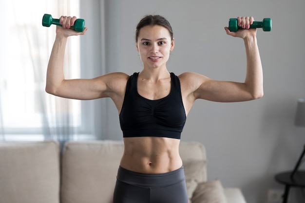 Front view of woman in athleisure lifting weights