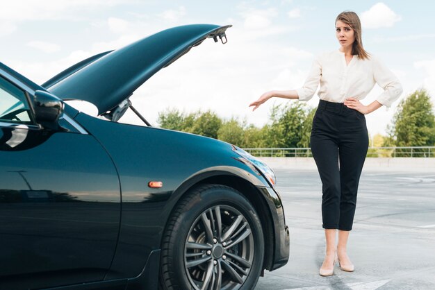 女性と黒い車の正面図