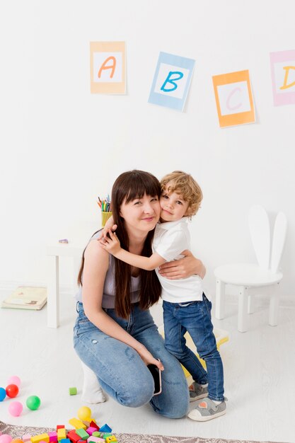 Front view of woman and boy posing together at home