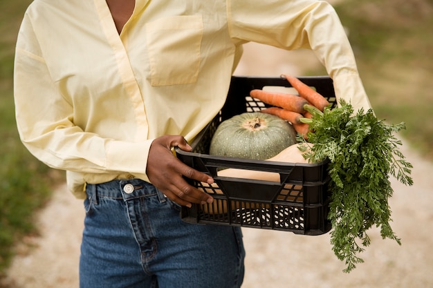 Free photo front view woman carrying box