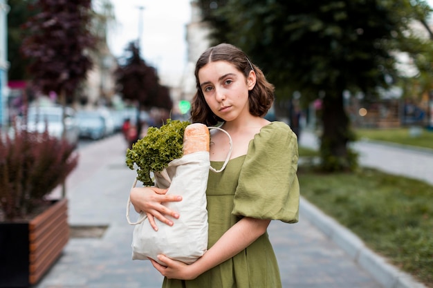 Front view woman carrying groceries bag