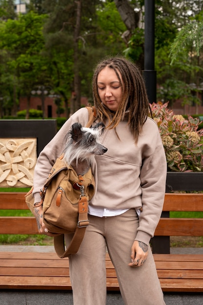 Front view woman carrying puppy in bag