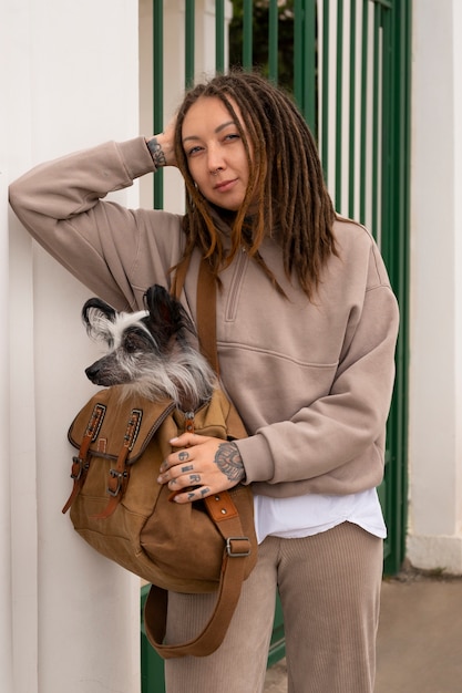 Front view woman carrying puppy in bag