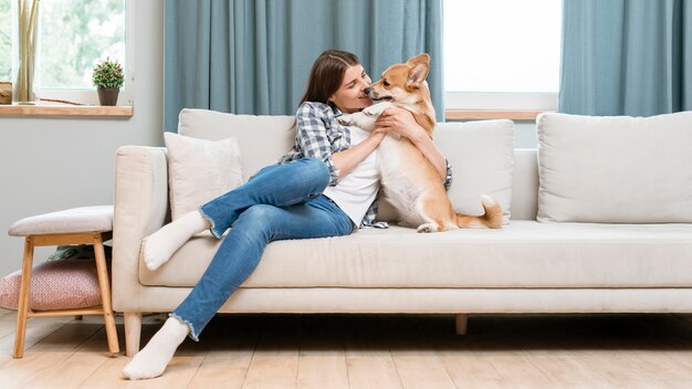 彼女のペットの犬とソファの上の女性の正面図