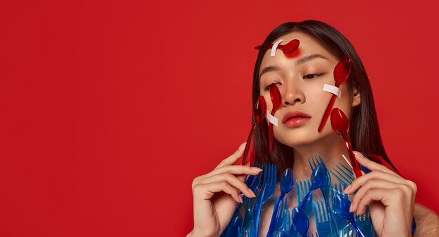 Front view woman covered in plastic tableware with copy space