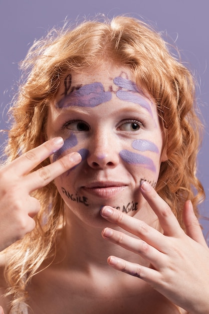 Front view of woman covering words with paint