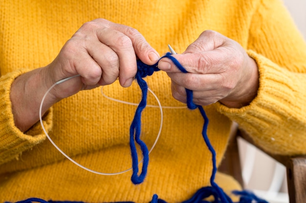 Free photo front view of woman crocheting with yarn