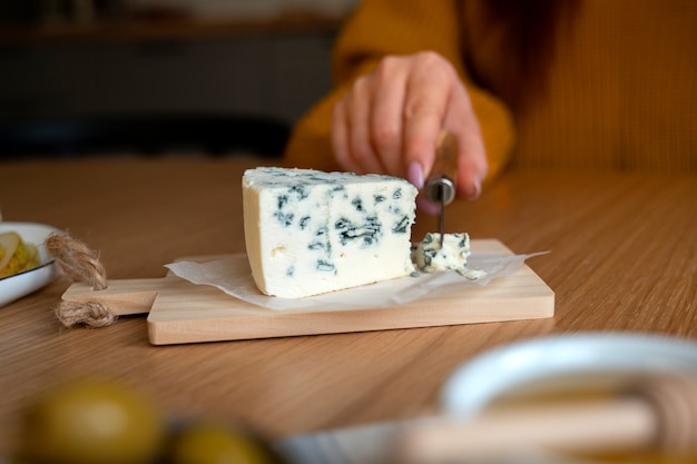 Free photo front view woman cutting cheese