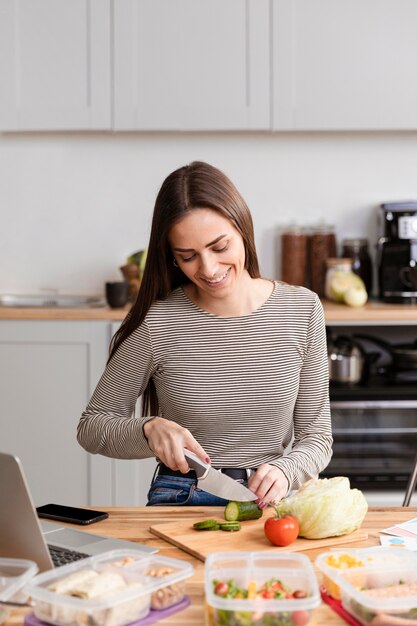 正面の女性が仕事で彼女の夕食を切る