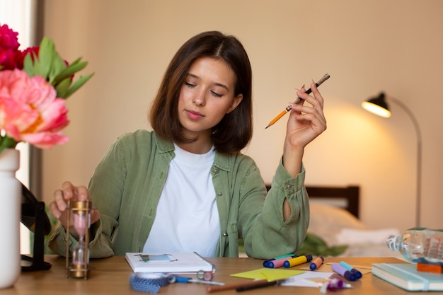 Foto gratuita donna di vista frontale che fa l'inserimento nel diario creativo