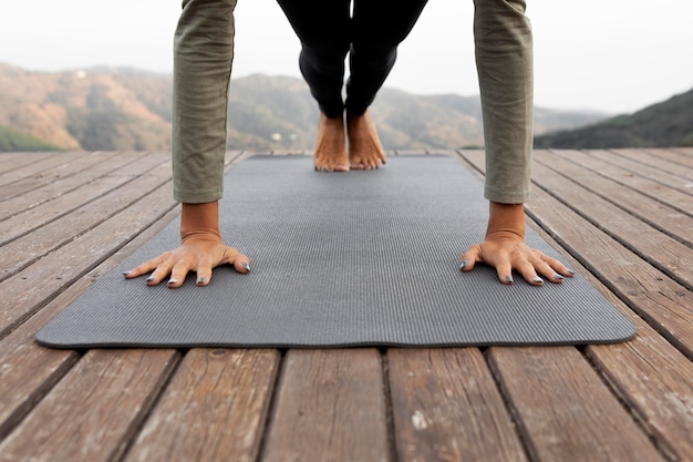 Front view of woman doing yoga outdoors on mat