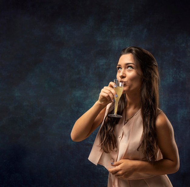 Free photo front view of woman drinking champagne