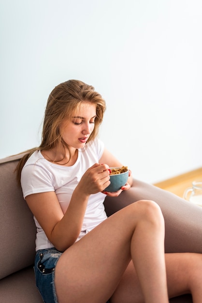 Front view woman eating cereals