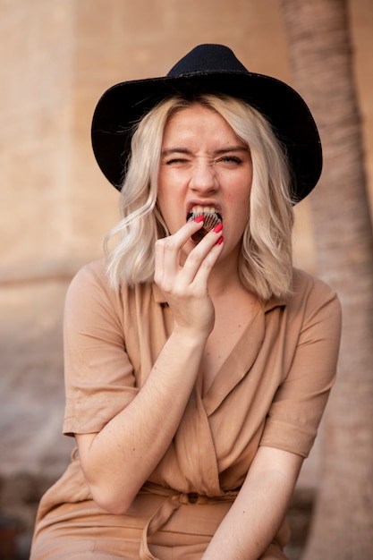 Front view of woman eating a cupcake outdoors